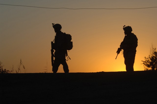 U.S. Army Soldiers assigned 1st Battalion, 66th Armored Regiment patrol a road at sunset