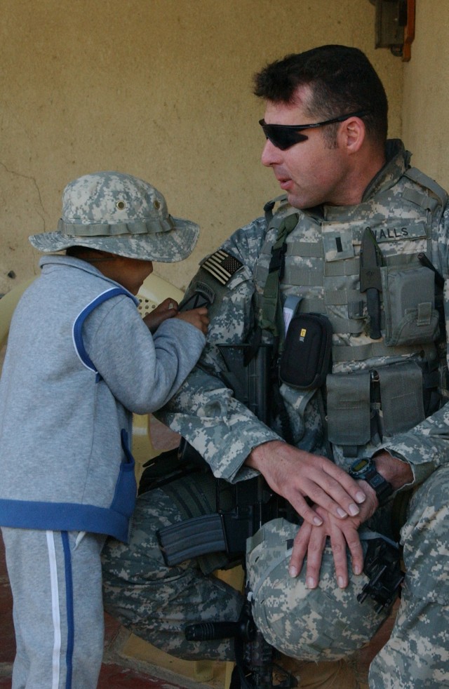 Local Child Inspects U.S. Army Patch
