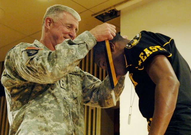 Lt.Gen. Robert L. Van Antwerp presents Marcus Gilchrist with the scholar athlete award