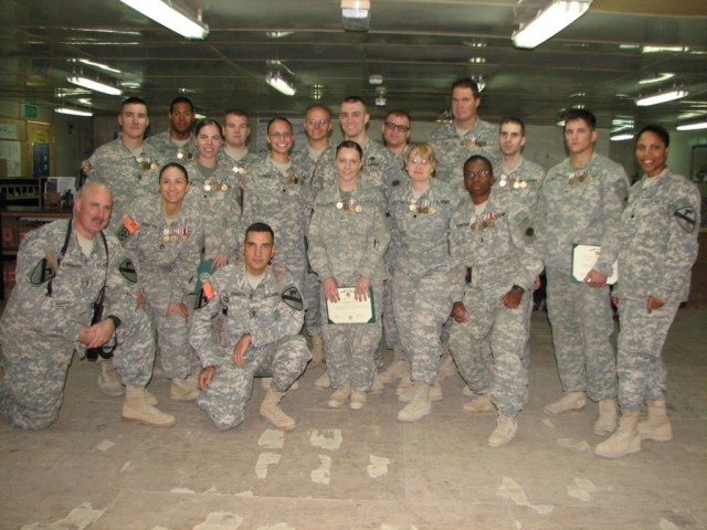 Command Sgt. Maj. Philip Johndrow, the Multi-National Division - Baghdad and 1st Cavalry Division command sergeant major (kneeling) and 15th Personnel Service Battalion leadership poses for a photo opportunity after the end of tour awards ceremony...