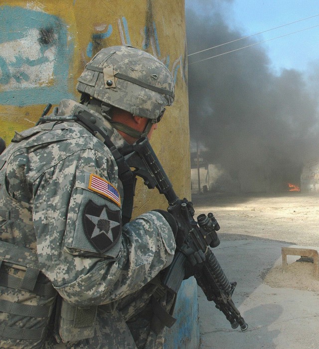 Operation Rock Wrench clears industrial section of Baqouba - A Soldier from the 1st Battalion, 38th Infantry Regiment, 4th Stryker Brigade Combat Team, 2nd Infantry Division, provides rear security as a weapons cache consisting of grenades and...