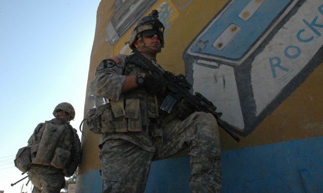 Operation Rock Wrench clears industrial section of Baqouba - Spc. Garrett Vogland of 1-12 Combined Arms Battalion, 3rd Brigade Combat Team, 1st Cavalry Division, provides security for Iraqi soldiers during Operation Rock Wrench Sept 22.  Iraqi...