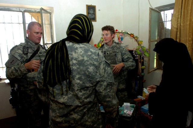 Through an Iraqi interpreter (center), Austin, Ind. native Capt. John Hendricks (left), squadron surgeon, and Spc. Kari Cordis, a medic, who hails from Terre Bonne, Ore. assist an Iraqi woman (right) by explaining to her the proper dosage of...