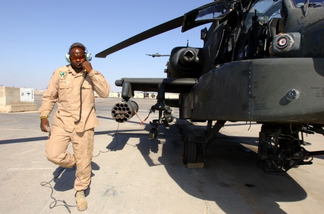 Topeka, Kan., native Spc. Anthony Crawford, an Apache crew chief for Company C, 1st "Attack" Battalion, 227th Aviation Regiment, 1st Air Cavalry Brigade, 1st Cavalry Division, walks around the aircraft to make some final inspections before he...