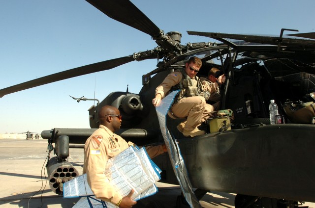 Deming, N.M., native Joshua Robertson (right), an AH-64D Apache attack helicopter pilot for Company C, 1st "Attack" Battalion, 227th Aviation Regiment, 1st Air Cavalry Brigade, 1st Cavalry Division, hands down a sun visor to Topeka, Kan., native...