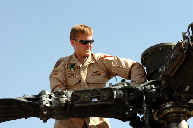 Belton, S.C., native Chief Warrant Officer 2 Russell Motes, an AH-64D Apache attack helicopter pilot for Company C, 1st "Attack" Battalion, 227th Aviation Regiment, 1st Air Cavalry Brigade, 1st Cavalry Division, inspects the rotor head of his...