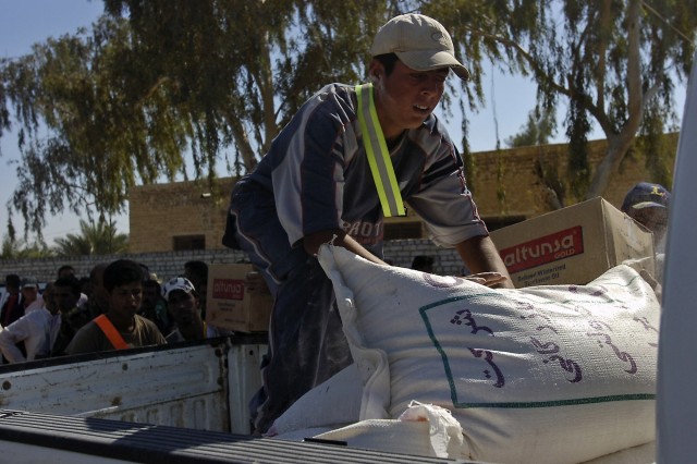A young man from Bob ab-Durib, a village outside of Baqouba, Iraq, stacks bags of flour into the back of a pickup truck during a humanitarian aid distribution Sept. 27. U.S. Army Soldiers from C. Company, 1-12 Combined Arms Battalion, 3rd Brigade Com...