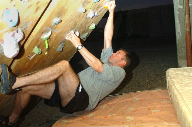 Advance, N.C., native Staff Sgt. Eddie Barrier, a flight medic for Company C, 2nd "Lobo" Battalion, 227th Aviation Regiment, 1st Air Cavalry Brigade, 1st Cavalry Division, concentrates as he moves up the climbing wall in Camp Taji, Iraq, built by...