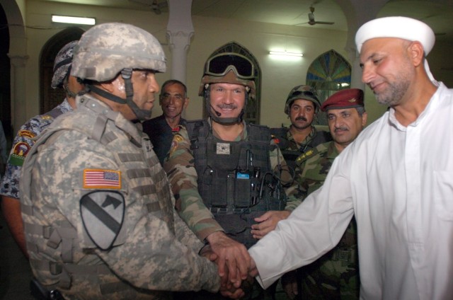 Col. Bryan Roberts, commander of the 2nd Brigade Combat Team, 1st Cavalry Division, Brig. Gen. Baha, commander of the 5th Brigade, 2nd Iraqi National Police Division and a sheik from a mosque in Karkh join hands to celebrate their meeting after the b...