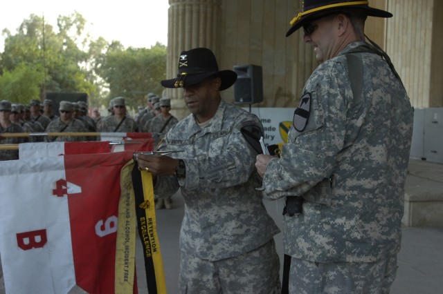 The 2nd Brigade Combat Team, 1st Cavalry Division commander, Col. Bryan Roberts, attaches a retention streamer to the guideon of Troop B, 4th Squadron, 9th Cavalry Regiment during a ceremony at Forward Operating Base Prosperity in central Baghdad Oct...