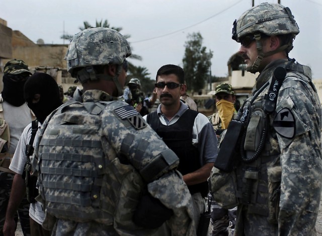 Sgt. First Class Timothy Frank Jr., a platoon sergeant in Bravo Troop, 6-9 Armored Reconnaissance Squadron, 3rd Brigade Combat Team, 1st Cavalry Division, talks with concerned local citizens and a council member about what types of masks are...