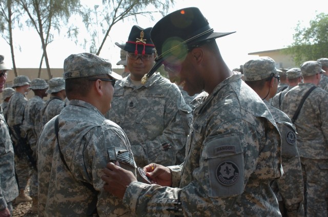 Capt. Timothy Gatlin, commander of Battery C, Fires "Hell" Squadron, 2nd Stryker Cavalry Regiment, attached to the 1st Brigade Combat Team, 1st Cavalry Division, places the combat patch on one of his Soldiers during a ceremony at Camp Taji, Iraq Oct....