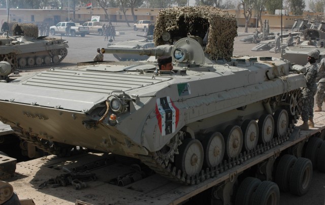 Iraqi armored vehicles from 3rd Brigade, 9th Iraqi Army Division drive onto the back of 15th Sustainment Brigade heavy equipment transports.  Unable to move themselves, 'Wagonmaster' troops provided the Iraqis movement support for the 450 mile trip f...