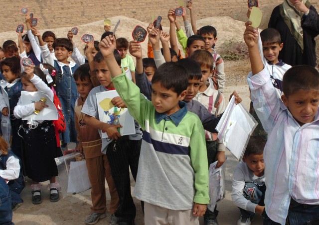 The students at an elementary school in Jerf Al-Mila, Iraq hold up their "Junior Hero" badge stickers after taking an oath to become honorary junior heroes during a visit to the school by Iraqi Army Soldiers from the 3rd Battalion, 2nd Brigade,...