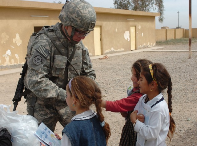 Handing out gifts to local Iraqi girls, 1st Lt. Tiffany Bilderback, squadron personnel officer for Fires "Hell" Squadron, 2nd "Stryker" Cavalry Regiment and a native of Colorado Springs, Colorado receives smiles from the children during a combined me...
