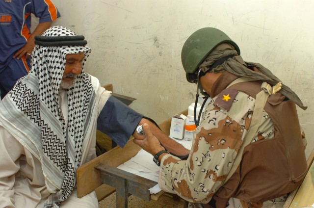 An Iraqi Army doctor from the 3rd Brigade, 6th Iraqi Army Division takes an elderly Iraqi man's blood pressure during a combined medical effort (CME) in Fira Shia, Iraq Oct. 19. The CME which resulted in more than 250 patients being treated for minor...