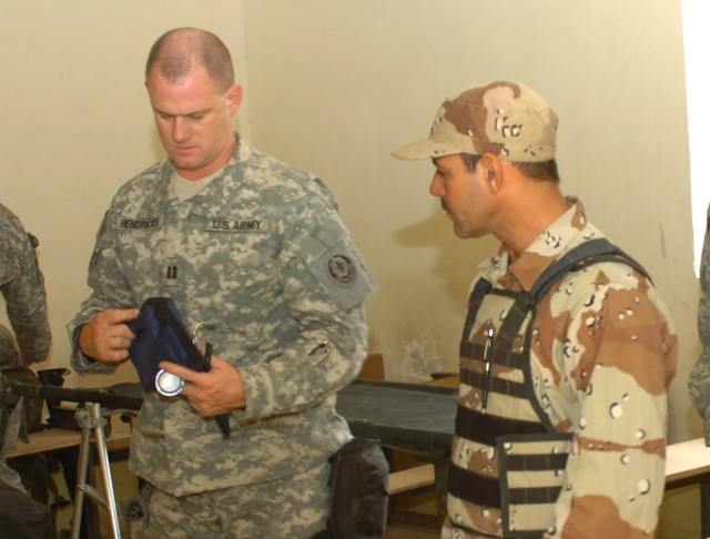 Capt. John Hendricks (left), squadron surgeon for the Fires "Hell" Squadron, 2nd "Stryker" Cavalry Regiment who hails from Austin, Ind., and an Iraqi Army medic from the 3rd Brigade, 6th Iraqi Army Division prepare medical equipment in a school in Fi...