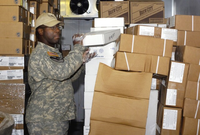 Fort Valley, Ga., native, Sgt. Danny L. Jones, food service shift leader with the Headquarters Support Company, Division Special Troops Battalion, 1st Cavalry Division, stores boxes of food in one of the Pegasus Dining Facility's six freezers at Camp...