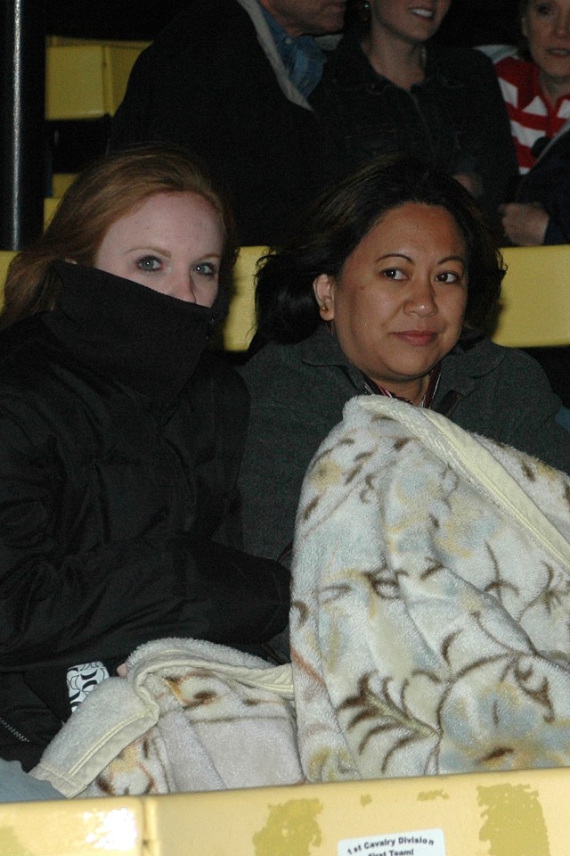Columbia, S.C., native Jenny Whitten and Guam native Grace Roldan keep warm under a blanket while waiting for Soldiers from the 15th Sustainment Brigade's Headquarters and Headquarters Company to return from a 15-month deployment to Iraq....