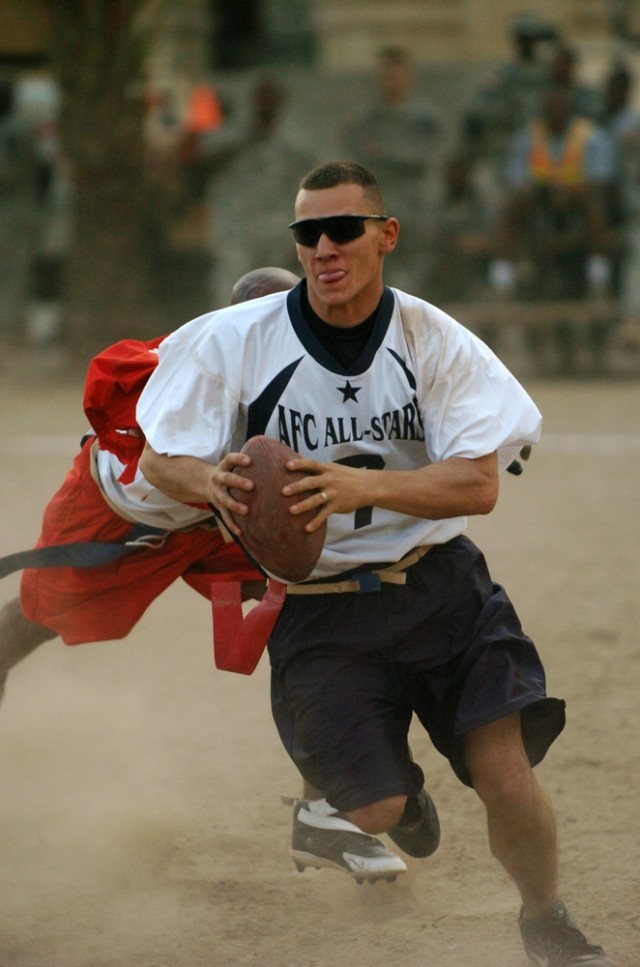 "AFC" quarterback Joshua Parker tries to scramble away from an "NFC" defender during the Black Jack Flag Football All-Star Game held on Forward Operating Base Prosperity in central Baghdad Oct. 20. The NFC won the game 41-36, stopping their...
