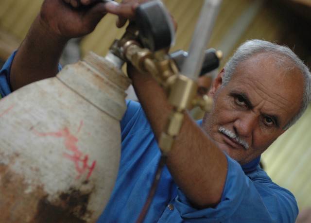A local citizen from Diyala province adjusts gauges on a helium tank while working at a Diyala Electric Industries factory in Baqouba, Iraq, Oct. 22. Diyala Electric Industries, which has been operating at a limited capacity since 2003, now...