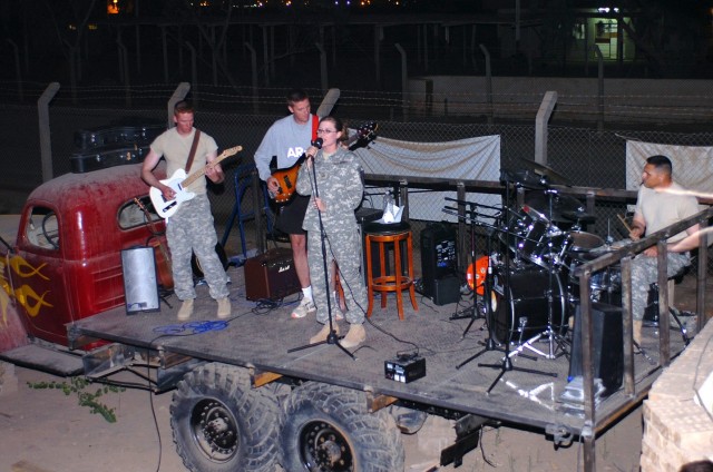 Fargo, N.D., native Sgt. Adrienn Falk, a personnel clerk for the 1st Air Cavalry "Warrior" Brigade, 1st Cavalry Division, belts out 90s rock music during "Open Mic Night" at the Mud House coffee shop at Camp Taji, Iraq Oct. 19. On the instruments...
