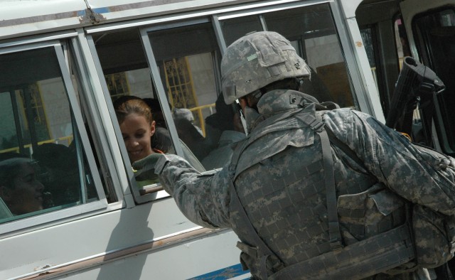 A local girl smiles as Lt. Col. Morris Goins, battalion commander for 1-12 Combined Arms Battalion, 3rd Brigade Combat Team, 1st Cavalry Division, passes her candy through a bus window, Oct. 21. Prior to Operations Arrowhead Ripper and Lighting Hamme...