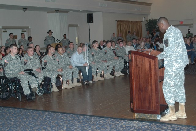 Purple Heart recipients look on as Lt. Col. Archie P. Davis III, the deputy commander for 1st Cavalry Division rear detachment, addresses the audience and begins the Purple Heart and Volunteer of the Month Ceremony held Oct. 23 at the Fort Hood...