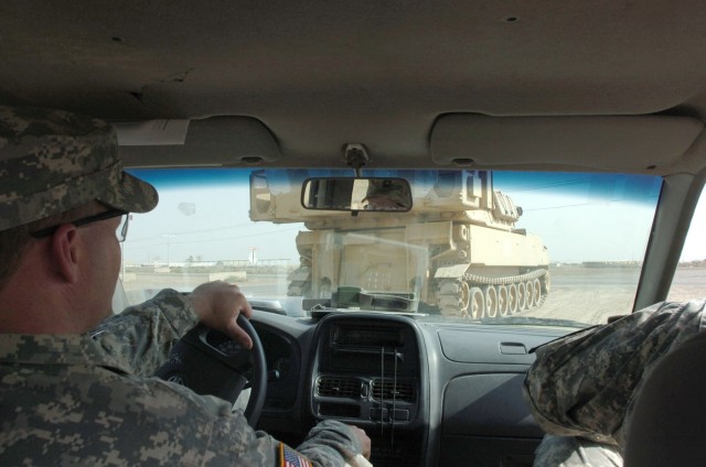 Bethlehem, Pa., native Master Sgt. James Alesick (left), an operations sergeant for the 1st Battalion, 82nd Field Artillery Regiment, serving as a competition evaluator, follows in his truck behind an M109A6 Paladin howitzer as it rolls down a...