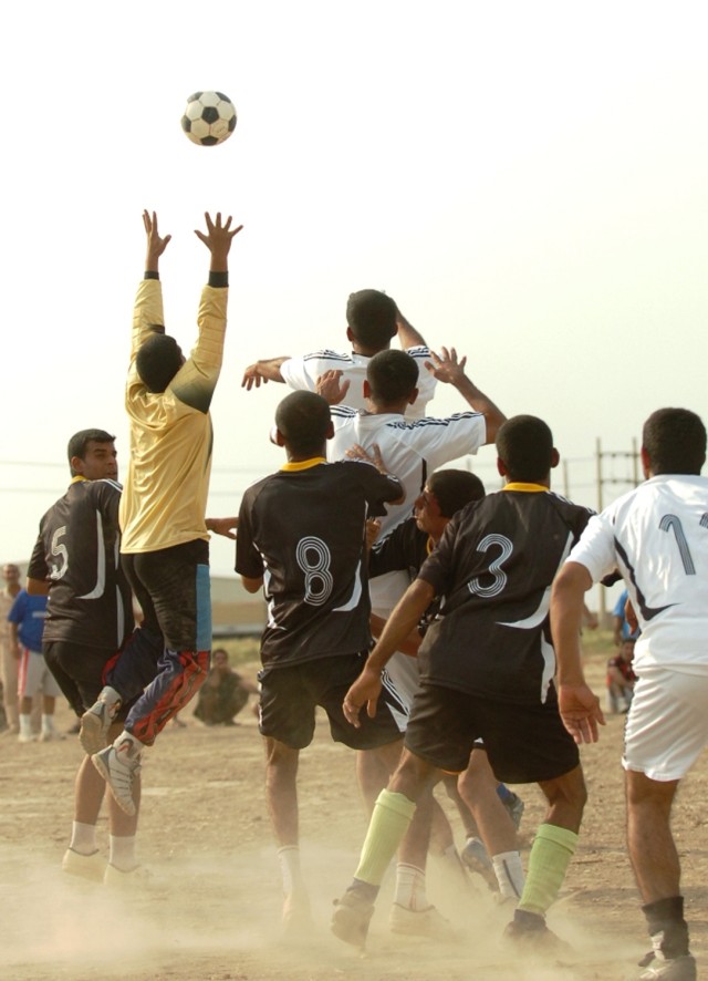 The goalie from the 2nd Battalion, 5th Brigade, 2nd National Police Division, goes up to catch the ball before the policemen from the 1st Battalion have a chance to score during the championship soccer game at the National Police Academy in Numaniyah...