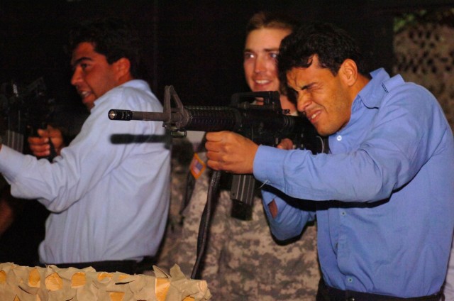 Stonington, Ill., native Sgt. David Ashbridge, a military police team leader for Headquarters and Headquarters Company, 1st Squadron, 7th Cavalry Regiment, coaches an Iraqi Police trainee during a preparatory class during a "shoot, don't shoot" scena...