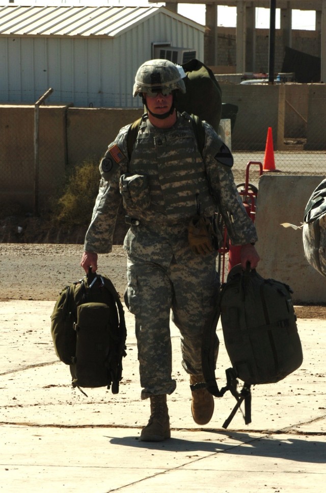 Orchard Park, N.Y., native Sgt. 1st Class Jon Spiller, a flight medic for Company C, 2nd "Lobo" Battalion, 227th Aviation Regiment, 1st Air Cavalry Brigade, 1st Cavalry Division, walks his gear to the waiting UH-60 Black Hawk helicopter at Camp Taji,...