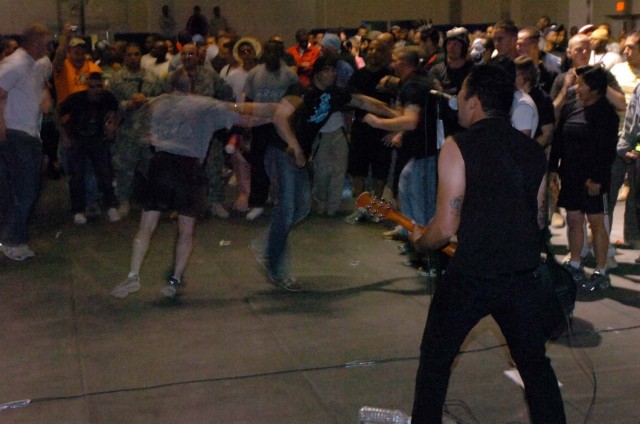 Lead singer and guitarist of the band Madison Avenue, Pfc. Samuel "Gonzo" Gonzalez, Jr., of the 571st Military Police Company, attached to 3rd Brigade Combat Team, 1st Cavalry Division, performs melodic emo songs for a dancing crowd of Soldiers...