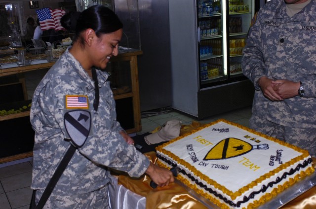 Killeen, Texas native Spc. Diana Mota, Headquarter Support Company, Division Special Troop Battalion, 1st Cavalry Division, cuts the cake designed with the 1st Cavalry Division logo celebrating her as the three millionth customer served a meal at the...