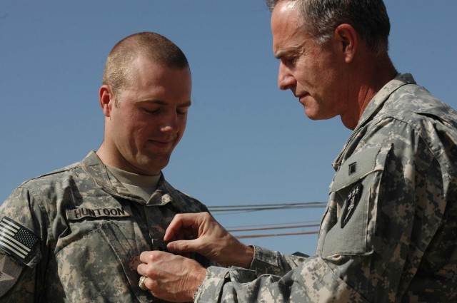 Newly-promoted Capt. David H. Huntoon III, a Soldier with 1st Battalion, 38th Infantry Regiment, 4th Stryker Brigade Combat Team, 2nd Infantry Division, watches as his dad, Maj. Gen. David H. Huntoon Jr., commandant for the U.S. Army War College,...