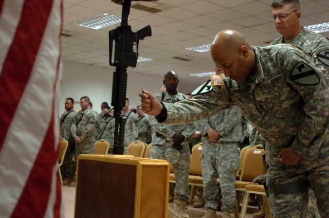 Gripping the memorial identification tags, Command Sgt. Maj. James Norman, the 3-8 Combined Arms Battalion, 3rd Brigade Combat Team, 1st Cavalry Division command sergeant major, pays respects to his fallen Soldier, Cpl. Adam Chitjian during a...