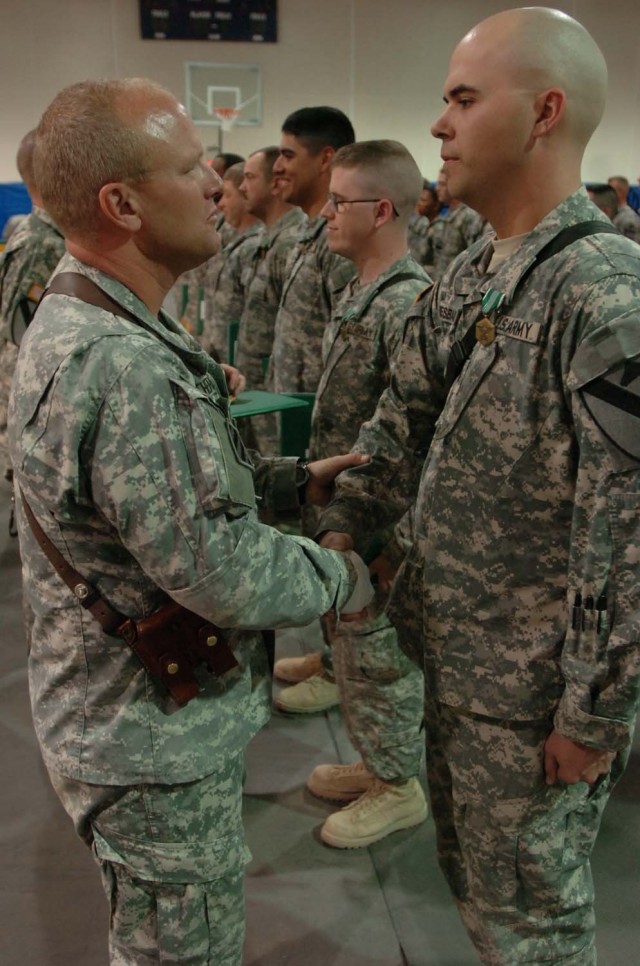 Col. David Sutherland, commander of 3rd Brigade Combat Team, 1st Cavalry Division, shakes the hand of a Soldier in 3rd Brigade Special Troops Battalion, 3rd BCT, during the spur ceremony.  Soldiers received their gold combat spurs, spur certificates ...