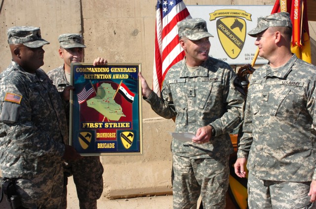 Maj. Gen. Joseph F. Fil, Jr. (second from right), commanding general, Multi-National Division Baghdad and 1st Cavalry Division, presents the 1st Cavalry Division First Strike award to Col. Paul E. Funk II (right), commander, 1st "Ironhorse" Brigade C...