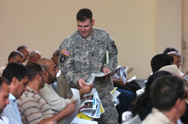 Capt. Gene Palka, 4th Squadron, 9th Cavalry Regiment's fire support officer, hands out fliers with information regarding reconciliation efforts and an upcoming job fair to attendees of a town hall meeting in Karkh Oct. 31. This was the first time a m...