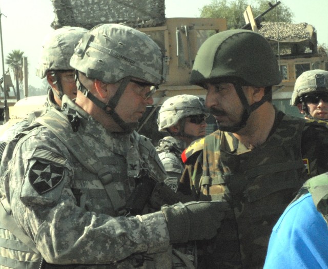 Col. Jeffrey Bannister, commander of the 2nd Infantry Brigade Combat Team, 2nd Infantry Division, makes a point to Iraqi Lt. Col. Quais, the executive officer of the 2nd Battalion, 4th Brigade, 1st Iraqi Army Division, before a walk through the Abu N...