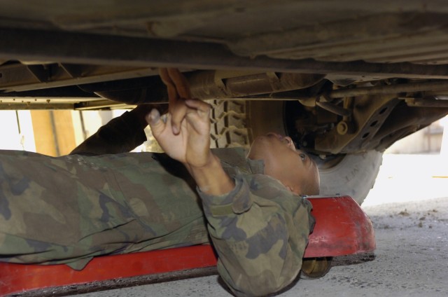 New Orleans native, Spc. Joshua Lummings, a light wheel mechanic with the Headquarters Support Company, Special Troops Battalion, 1st Cavalry Division, checks for damage on the bottom of an unarmored humvee in the dispatch lane of the STB motor...