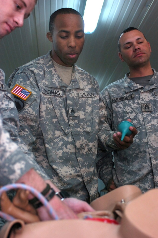 Sgt. Chris Thomas (center), a Camden, N.J., native and member of the 1st Battalion, 5th Brigade, 6th Iraqi Army Military Transition Team, 2nd Brigade Combat Team, 1st Cavalry Division, trains on emergency medical techniques during a class on...