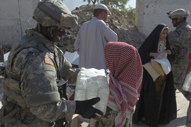 During a humanitarian aid mission conducted by Company E, 1st Battalion, 5th Cavalry Regiment, which is currently attached to the 4th Squadron, 9th Cavalry Regiment, 2nd Brigade Combat Team, 1st Cavalry Division, Aug. 16, Spc. Emmanuel Danso hands...
