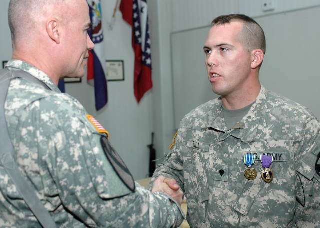 Wichita, Kan., native Spc. Benjamin Full, a UH-60 Black Hawk helicopter crew chief for Company A, 3rd "Spearhead" Battalion, 227th Aviation Regiment, 1st Air Cavalry Brigade, 1st Cavalry Division, shakes the hand of Traverse City, Mich., native Col. ...
