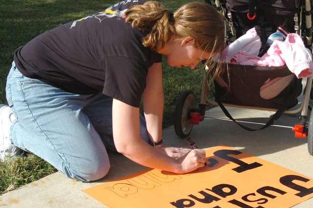 Sandy, Utah, native Suzzie Sachs, the Family Readiness Group leader for the 2nd Brigade Special Troops Battalion, 2nd Brigade Combat Team, 1st Cavalry Division, puts the finishing touches on a sign welcoming home two Soldiers from her husband's...