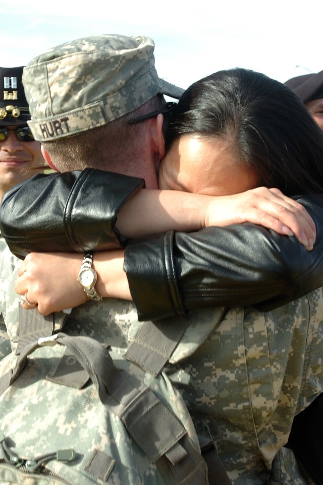 Taegu, South Korea, native Capt. Hwajin Hurt, with the Headquarters and Headquarters Company, III Corps, throws her arms around her husband Capt. Donnie Joe Hurt, the assistant operations officer for the 2nd Brigade Combat Team, 1st Cavalry...