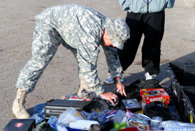 Indianapolis native Staff Sgt. Veral Sullivan, a training noncommissioned officer with Headquarters and Headquarters Company, Special Troops Battalion, 1st Cavalry Division, checks a Soldier's belongings to make sure the items will clear a customs in...