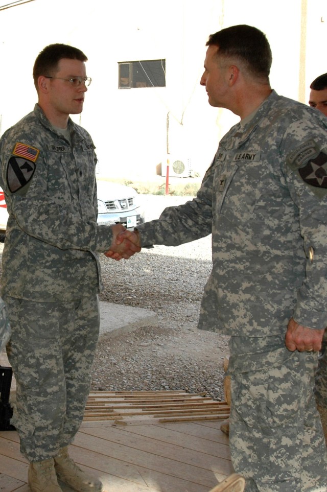 Col. Jon Lehr, commander, 4th Stryker Brigade Combat Team, 2nd Infantry Division who hails from Dover, Pa. shakes the hand of Williamsburg, Pa. native Spc. Brett Snauffer who works in the 1st Battalion, 82nd Field Artillery Regiment's fire direction ...