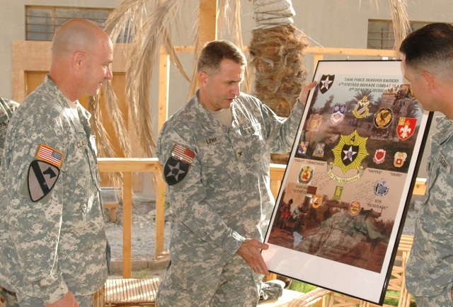 Dover, Pa., native Col. Jon Lehr (center), commander, 4th Stryker Brigade Combat Team, 2nd Infantry Division presents a 4th SBCT poster to 1st Battalion, 82nd Field Artillery senior leaders, San Diego native Lt. Col. Martin Clausen (left), 1-82 comma...