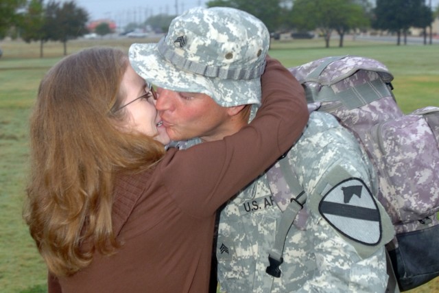 Gadsden, Tenn., native Lori Hall welcomes home her husband, Tampa, Fla., native Sgt. Eric Hall, with Company F, 2nd Battalion, 227th Aviation Regiment, 1st Air Cavalry Brigade, 1st Cavalry Division, with a big hug and kiss during a welcome home cerem...